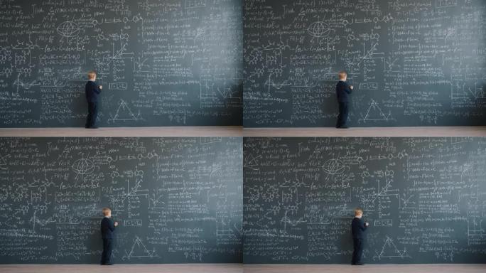 聪明的小男孩在学校的大黑板上写方程的慢动作