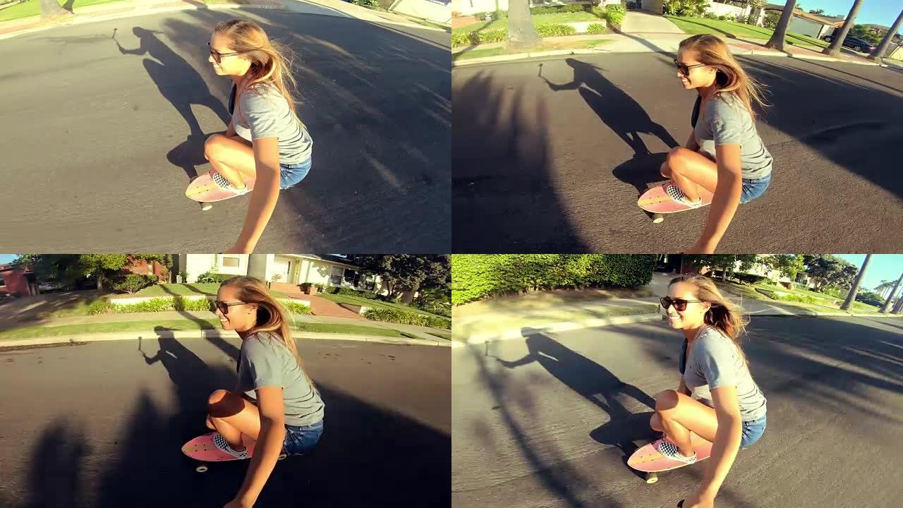 快乐关怀女孩在日落时拿着自拍相机在街上滑板的观点