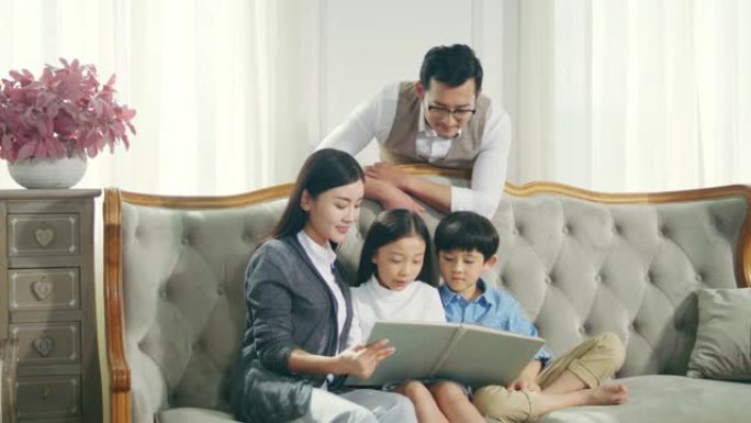 亚洲母亲和父亲在家与儿子和女儿一起读书