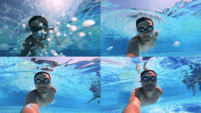 一个人在游泳池水下游泳时拿着相机。暑假概念。