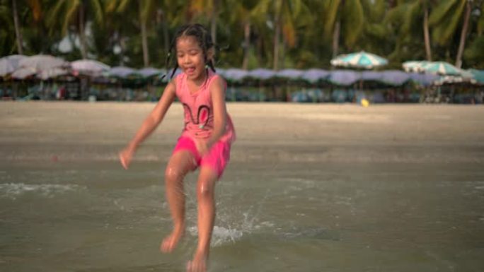 快乐的女孩在海滩上的水上跳跃