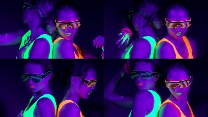 在霓虹灯下跳舞的美丽性感女性的慢镜头。夜总会，派对概念。