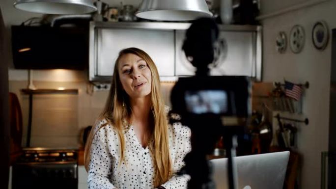 快乐年轻成功的高加索金发时尚博主在家里用专业相机慢动作拍摄vlog视频。