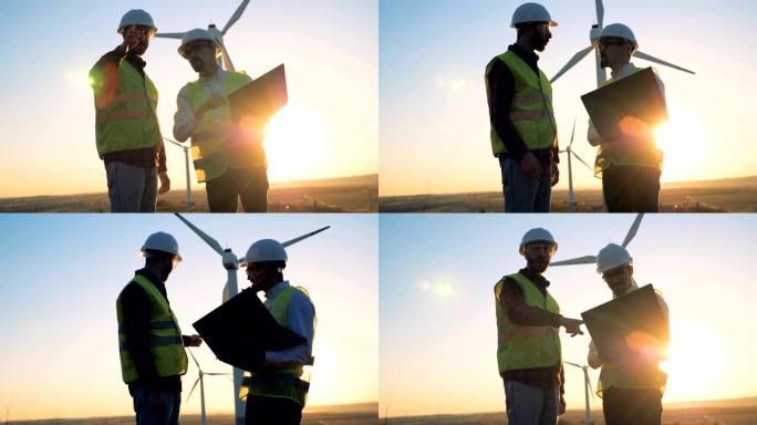 日落景观，两名工程师在一组涡轮机塔旁边交谈。可再生替代能源，环保理念。