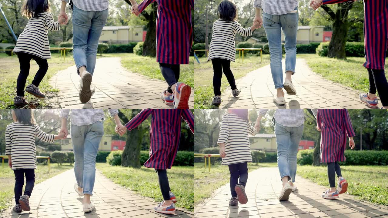 日本父母姐妹牵手在公园散步