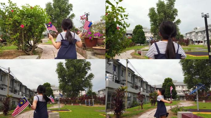 一名华裔女孩裹着马来西亚国旗在公园里奔跑