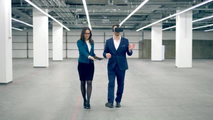 一个男人在与现代技术女商人一起工作时戴着VR眼镜。