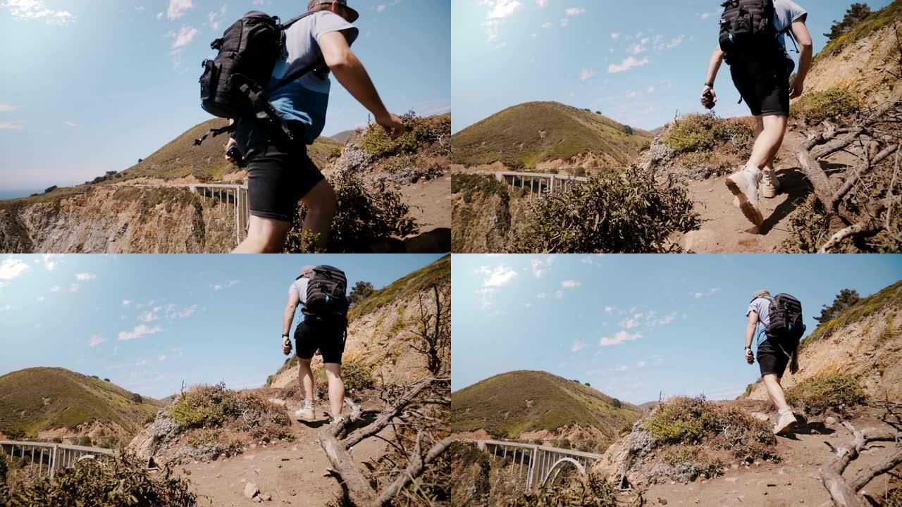 年轻的成人旅游摄影师男子，带着专业背包徒步旅行，在比克斯比峡谷大桥观看史诗般的风景。