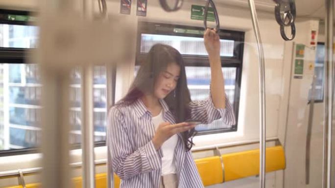 亚洲年轻女子在地铁上使用智能手机