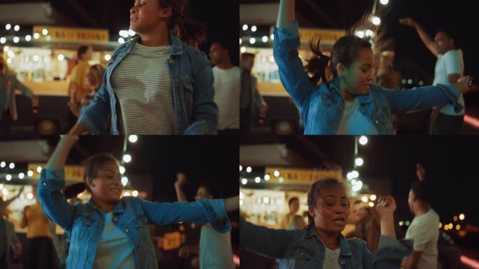 一群朋友正在街头食品汉堡咖啡馆外面举行聚会。一个年轻美女随着音乐跳舞的肖像。今天是现代社区的夜晚。每