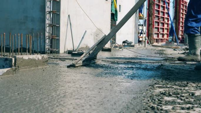 一名工人将水泥地板水平。