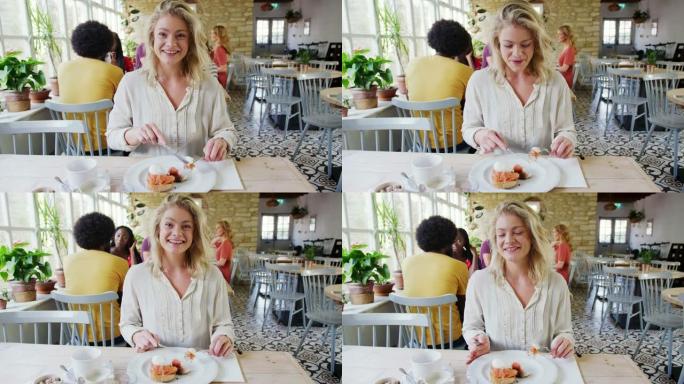 年轻的成年女性吃早午餐，在一家餐厅做出反应并与相机交谈，这是从同伴的POV拍摄的
