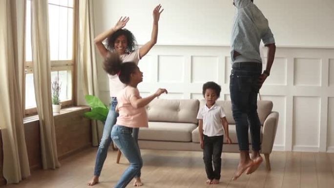 快乐的非洲裔美国父母和可爱的孩子在家里跳舞
