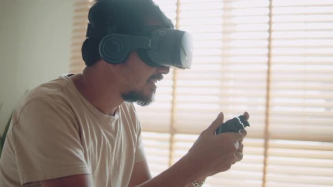 亚洲男子在家里的卧室里玩VR视频游戏。