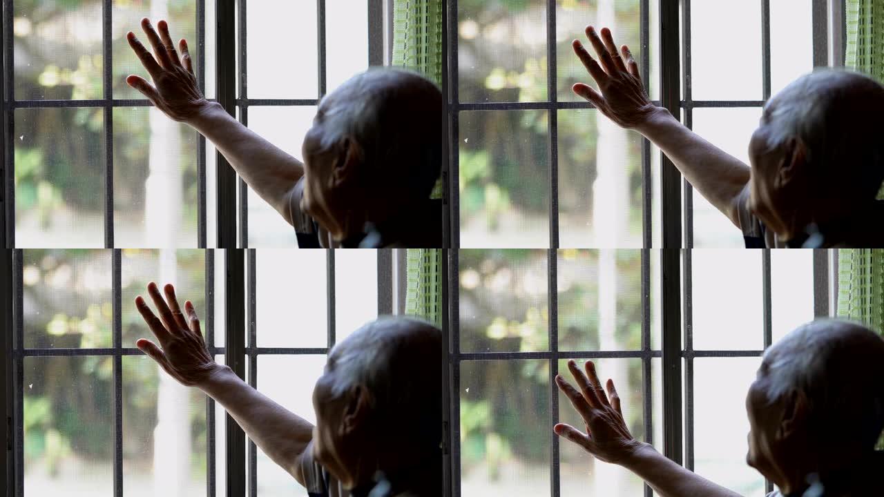 泰国老人摸窗户，看起来像他想出去