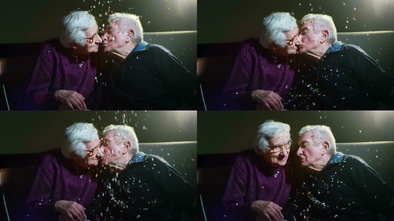 90岁生日时温柔的老夫妇玩五彩纸屑和慢动作接吻
