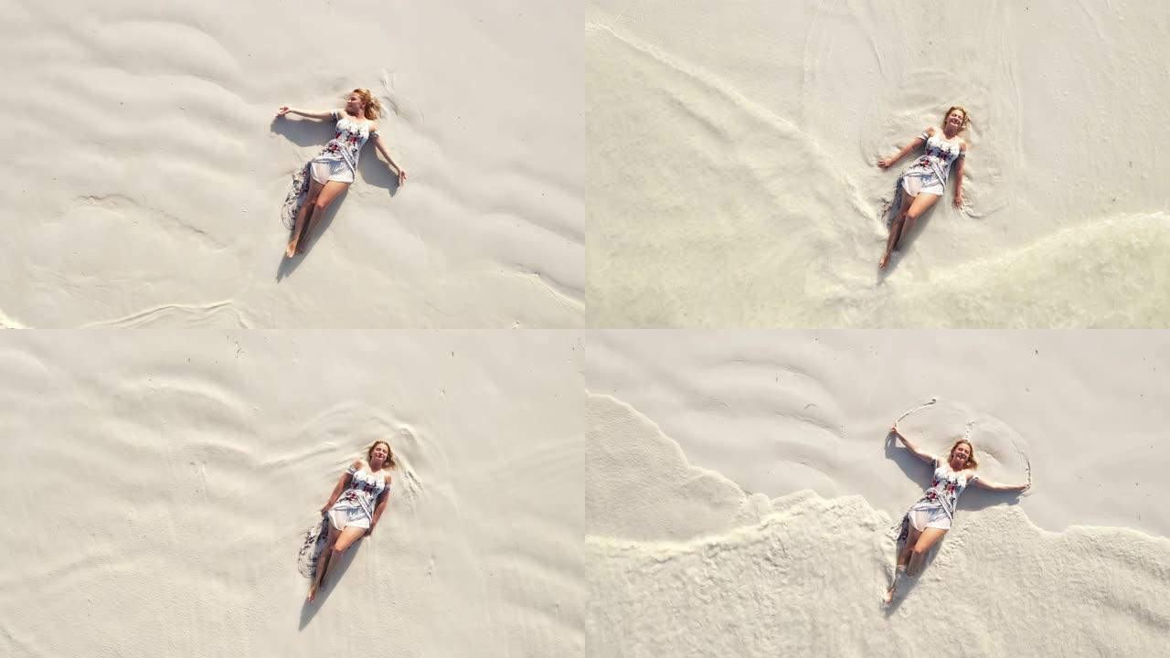穿着太阳裙躺在沙滩上的空中快乐女人
