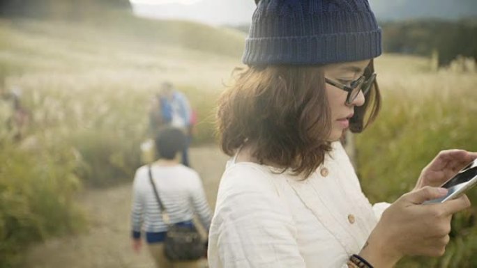 亚洲旅游女子用相机在山腰拍照