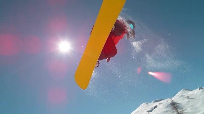 慢动作特写: 滑雪者在晴朗的蓝天上跳跃并飞越太阳