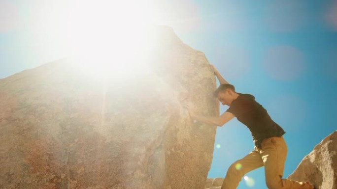 男子攀岩用镜头耀斑伸向外面的岩石