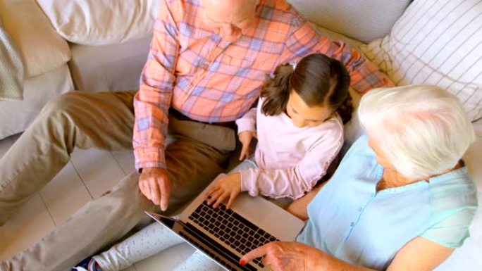 在舒适的家庭4k中使用笔记本电脑的高加索多代家庭的高角度视图