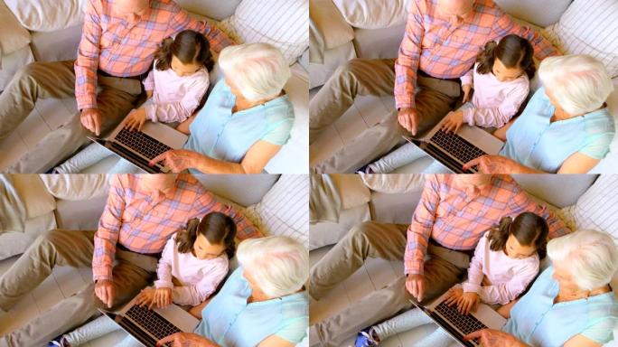 在舒适的家庭4k中使用笔记本电脑的高加索多代家庭的高角度视图