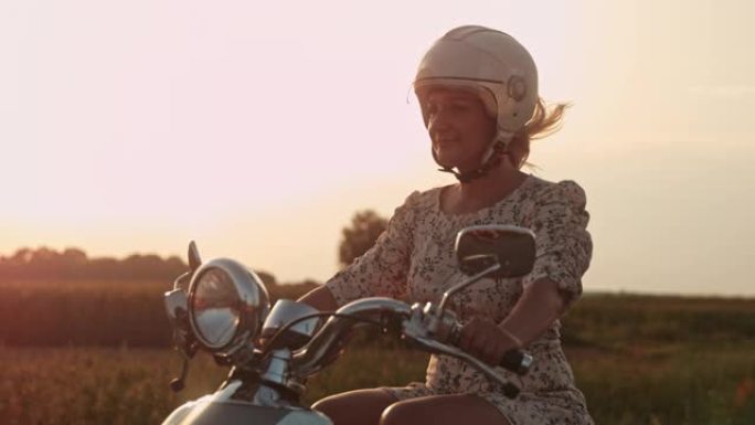 超级SLO MO女人在日落时在乡下骑踏板车