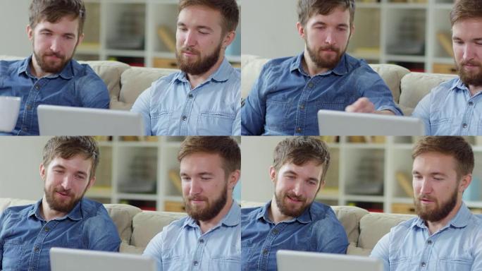 男性双胞胎用笔记本电脑浏览互联网