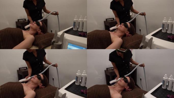 黑人美容师在水疗中心用激光对腋下的女性顾客进行激光治疗