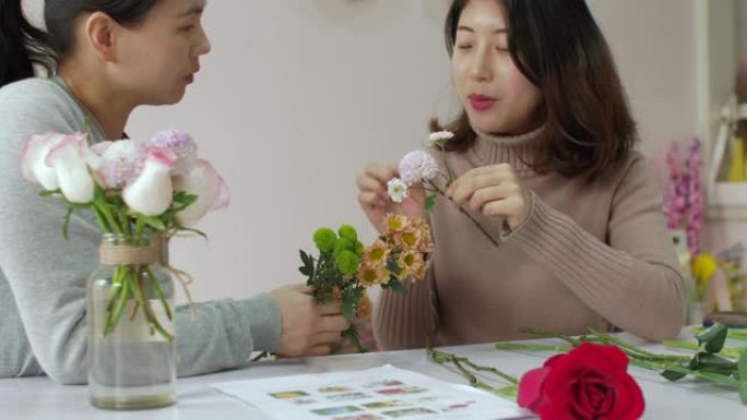 女孩花店正在训练她的朋友如何制作美丽的花束