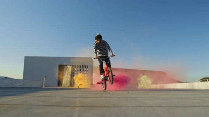 BMX骑手在屋顶上跳跃并使用烟雾弹