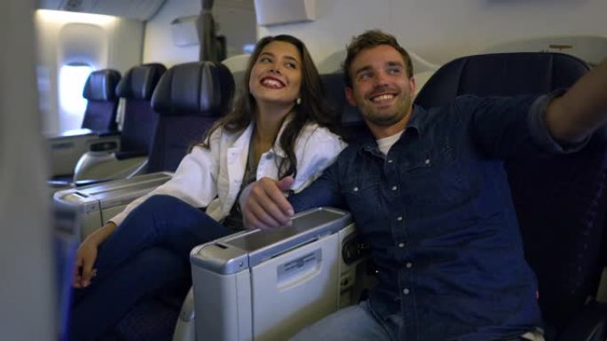 幸福的夫妇在一次商业飞行中自拍，为他们的逃亡感到兴奋