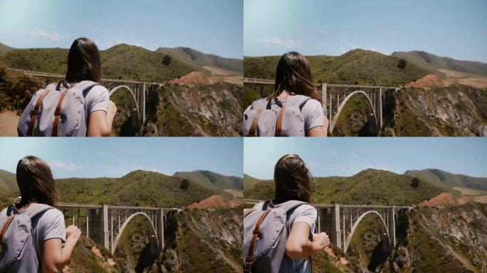 在比克斯比峡谷大桥，年轻的旅行者女人背着背包徒步旅行到令人难以置信的远景点。