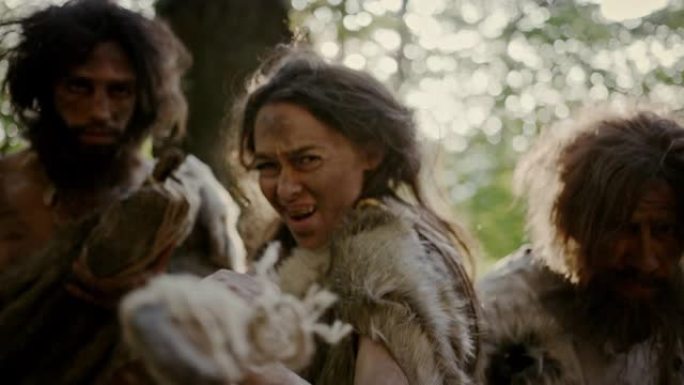 女性领袖和两名穿着动物皮的原始穴居人用石尖矛攻击敌人，尖叫，捍卫史前时代的洞穴和领土。尼安德特人/智