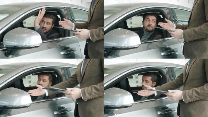 好看的男人买家与坐在车里触摸闪亮汽车的销售经理交谈
