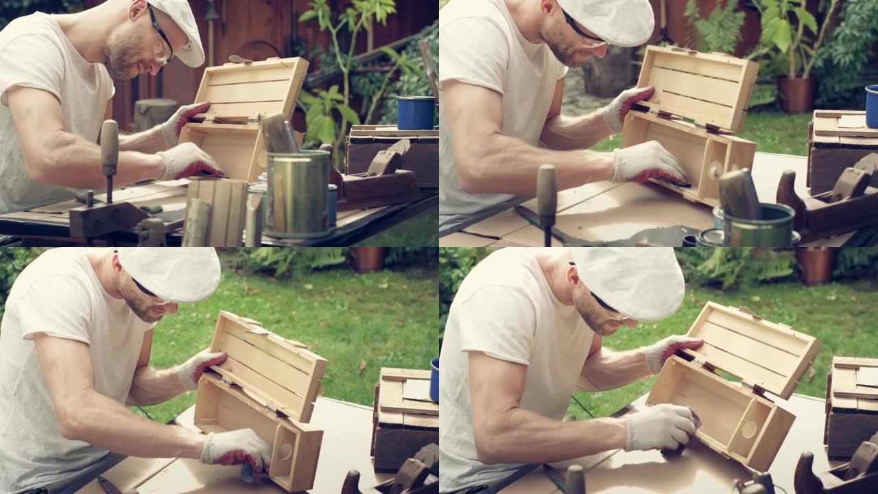 花园DIY。男人打磨木制家具。