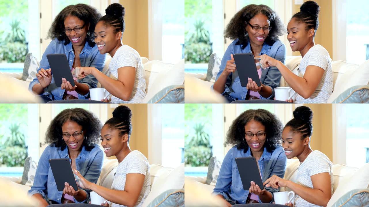 年轻女子和她的妈妈在数字平板电脑上看照片