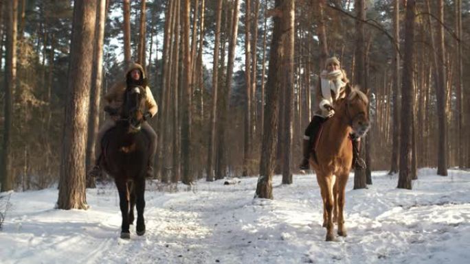 欢乐的夫妇在冬季森林里骑马