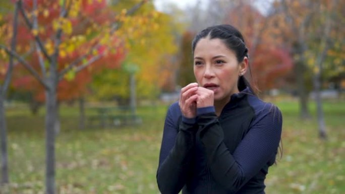 单身成年女性在秋季在公园锻炼前热身