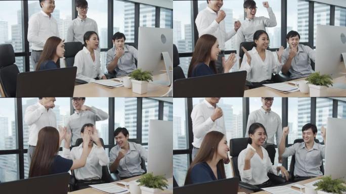 4K UHD: 一群亚洲商务员工在现代办公室欢呼和击掌。