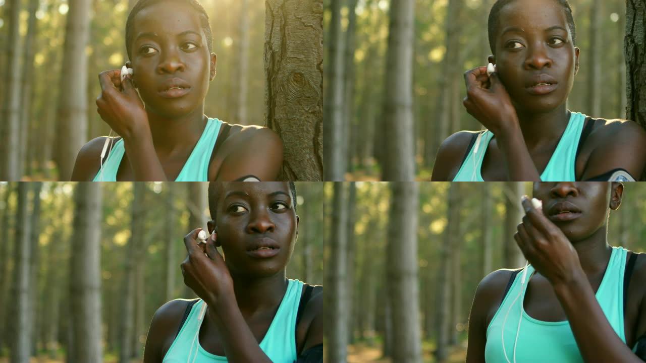 女性慢跑者把耳机放在耳朵里4k