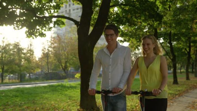 特写: 微笑的高加索夫妇在风景秀丽的大道上骑着电动踏板车