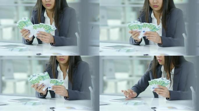 女商人数数欧元钞票并使用数字平板电脑