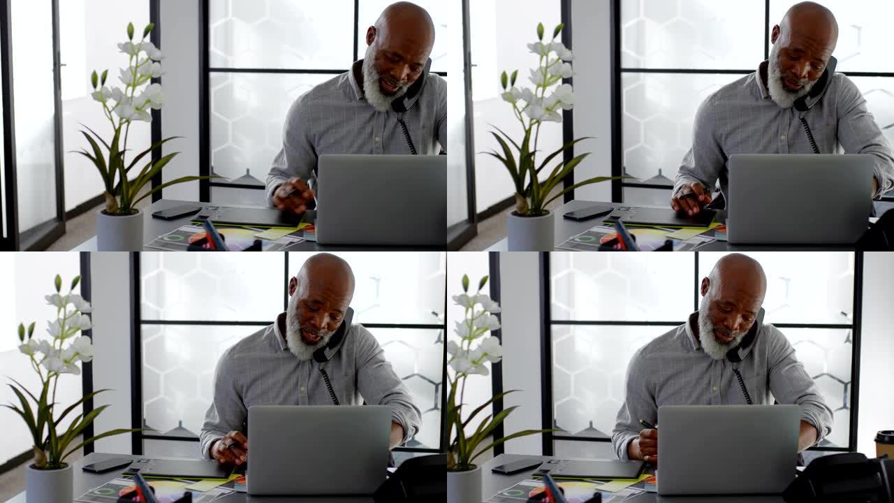 男子在4k桌上使用笔记本电脑时在固定电话上交谈