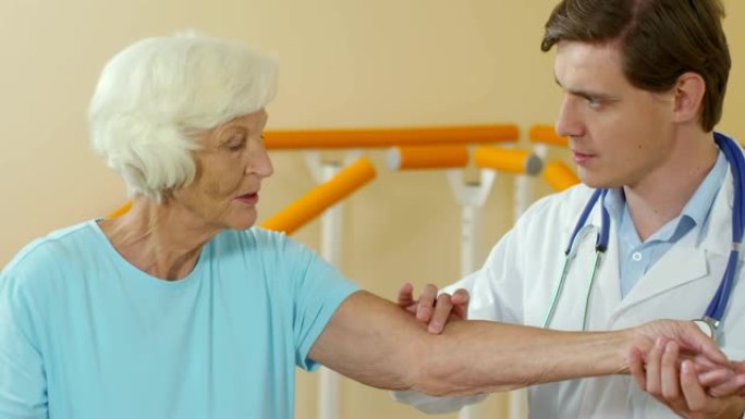 理疗师检查老年患者手臂敏感性