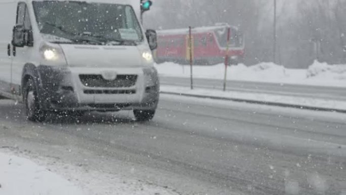慢动作: 白色货车在强烈的暴风雪中沿着光滑的道路行驶。