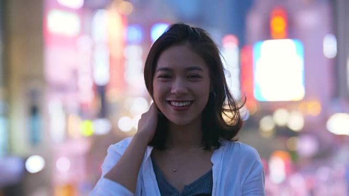 美丽的亚洲女孩的肖像晚上在镜头前微笑