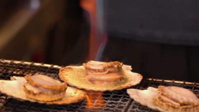 日本街头市场炉子上的SLO MO烤扇贝
