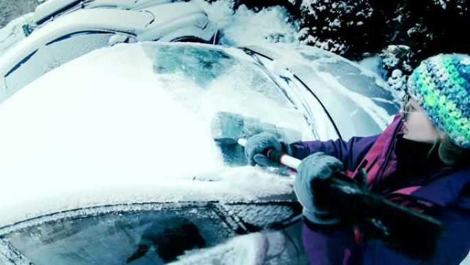 女司机刮雪覆盖车窗