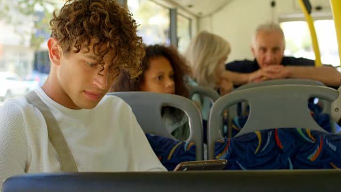 乘坐4k公交车时使用数字平板电脑的男性通勤者
